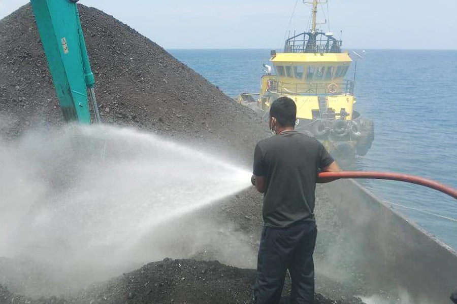 Petugas menyemprot air untuk memadamkan asap dari batubara di atas kapal tongkang, Kamis 2 November 2023 (foto: Polsek Maurole)